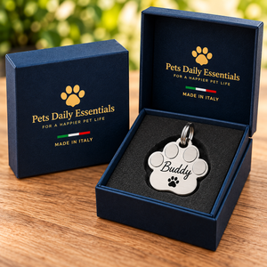 Illustrative Paw Stainless Steel pet ID tag inside navy-and-gold Pets Daily Essentials box with Italian flag